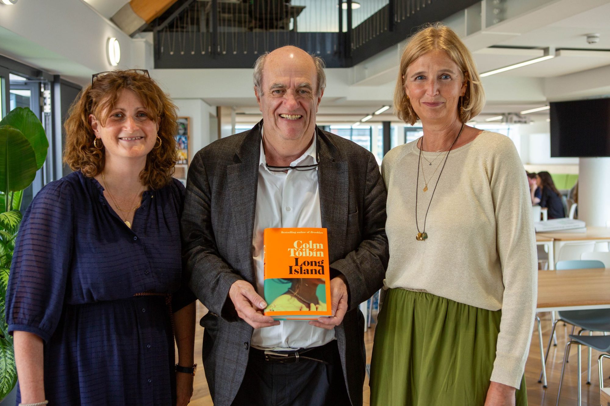 Author holding his book with three guests at a launch