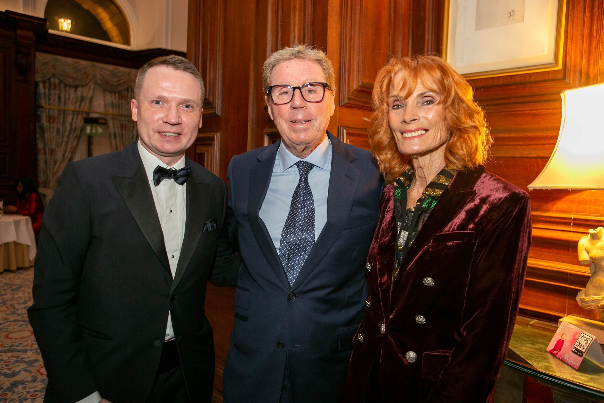 Three dinner guests in a wood panelled room