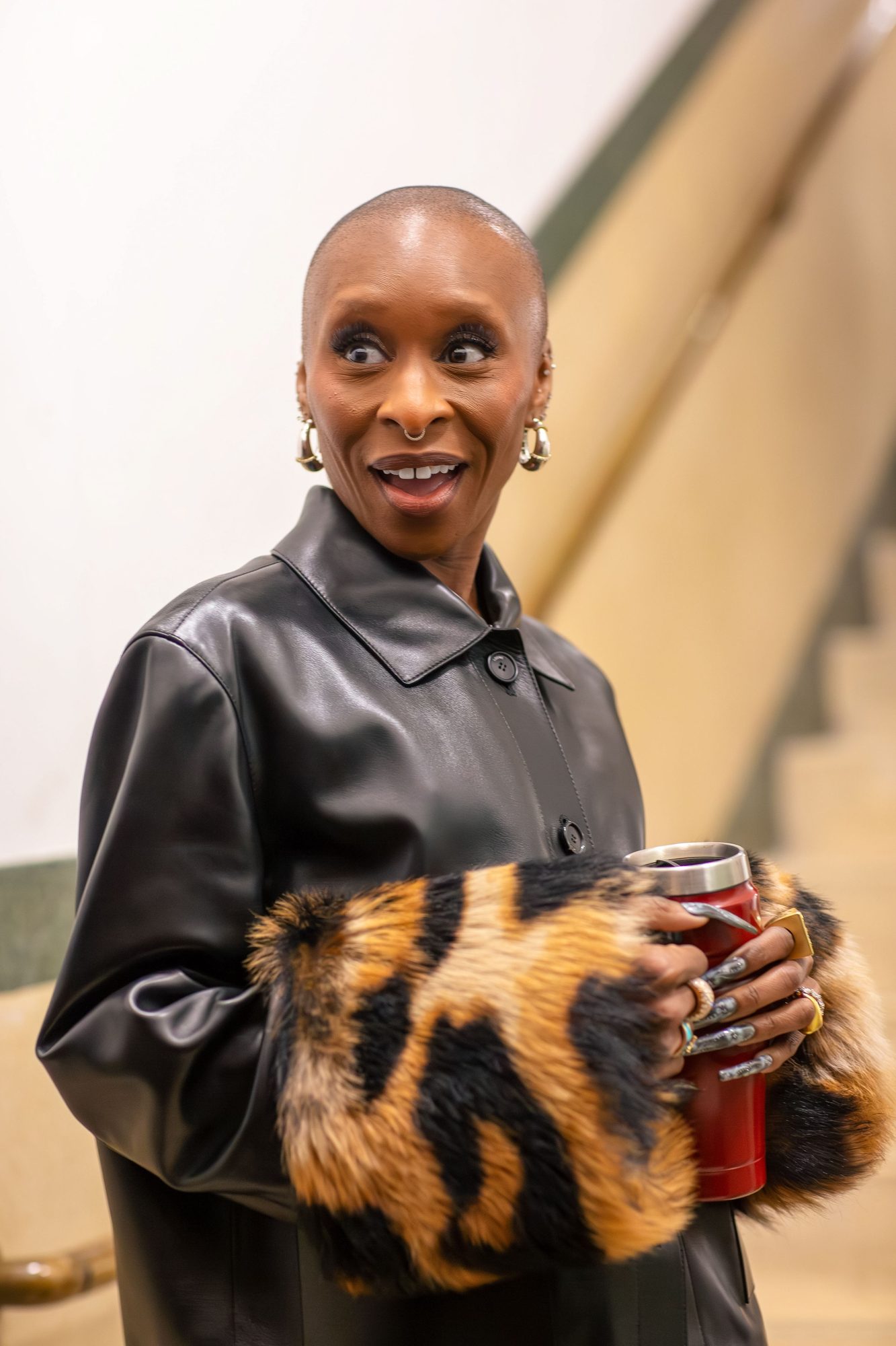 Guest in a leather jacket with leopard print cuffs holding a drink