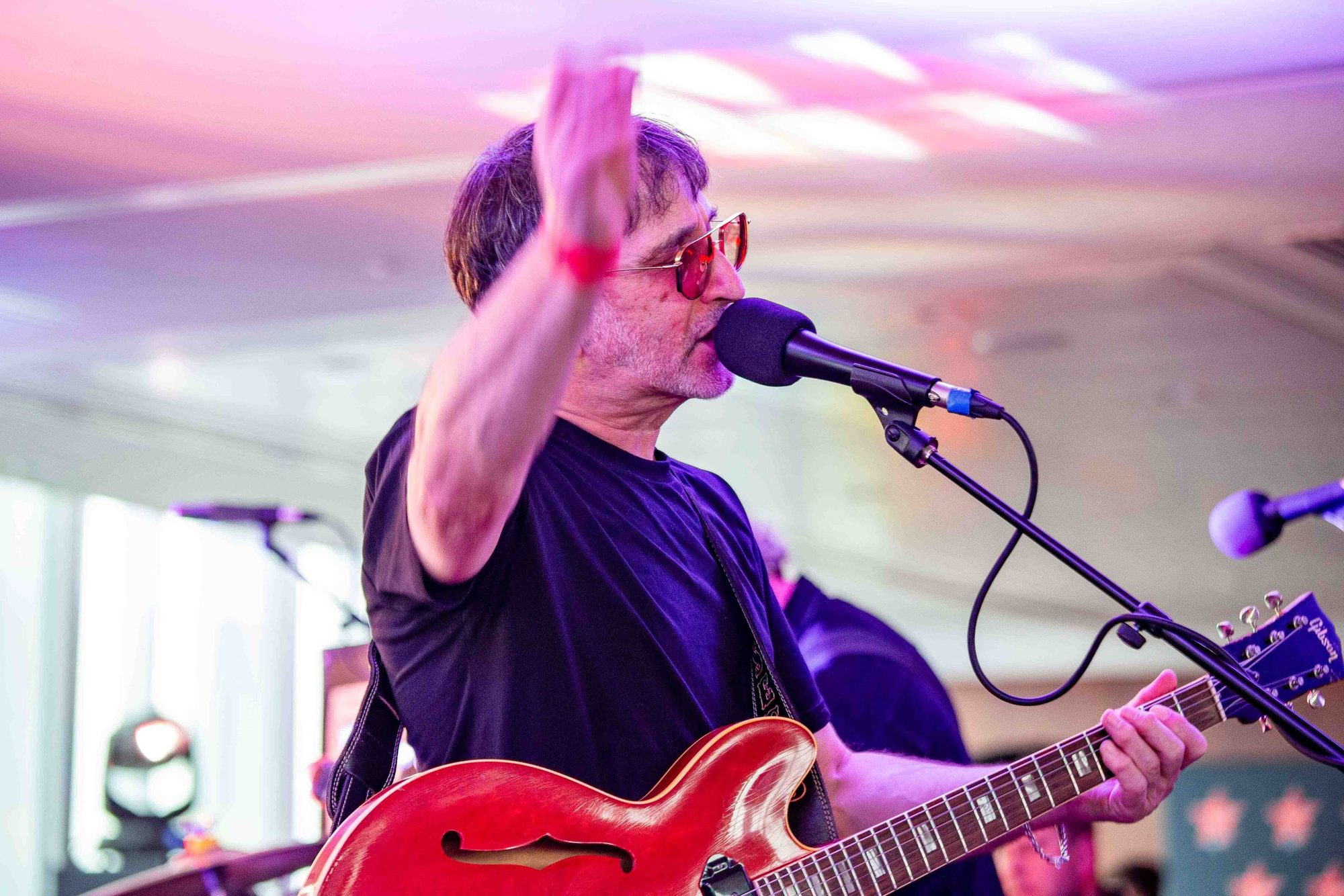 Singer with a red guitar at the microphone