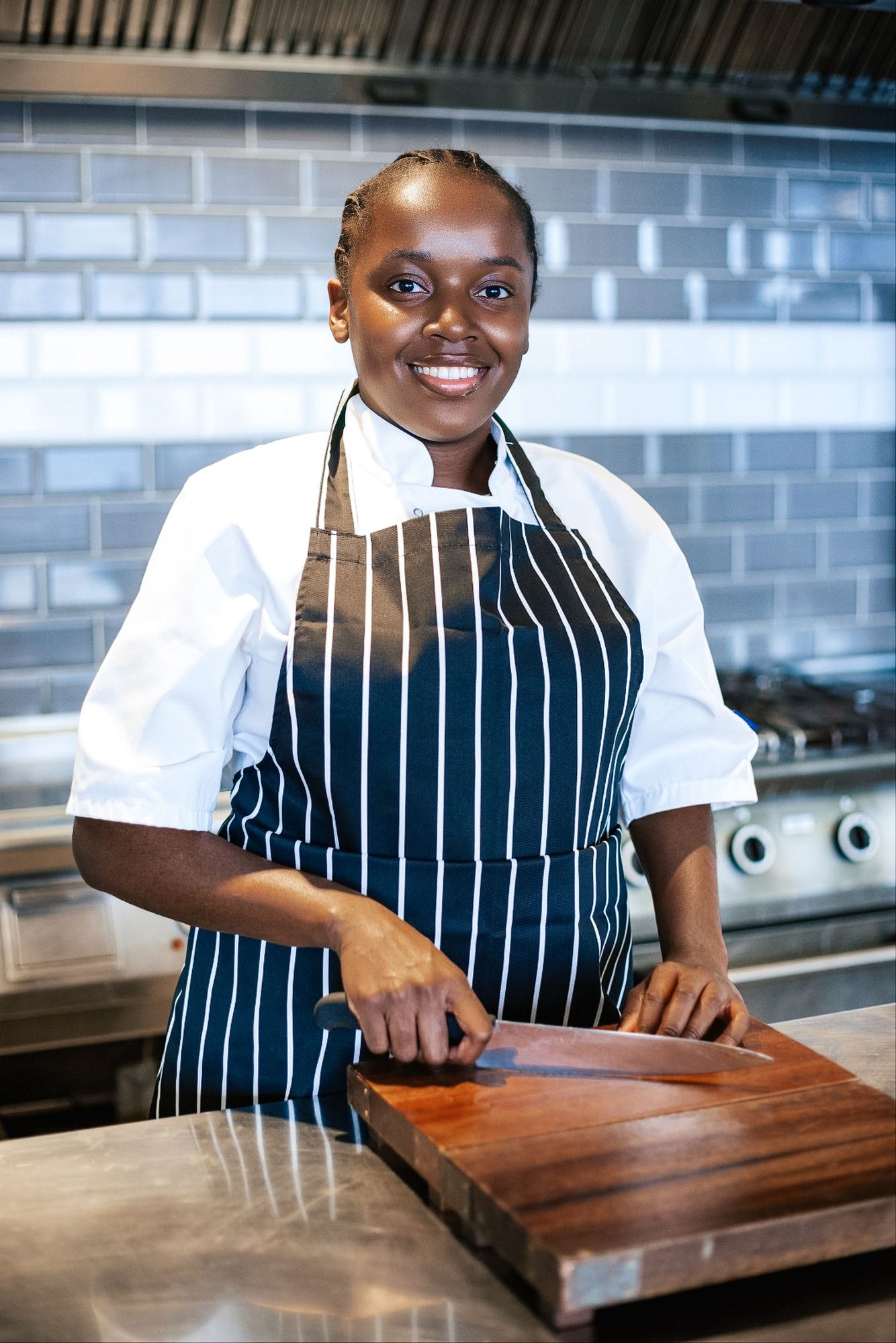Chef in a striped apron at work at a kitchen counter