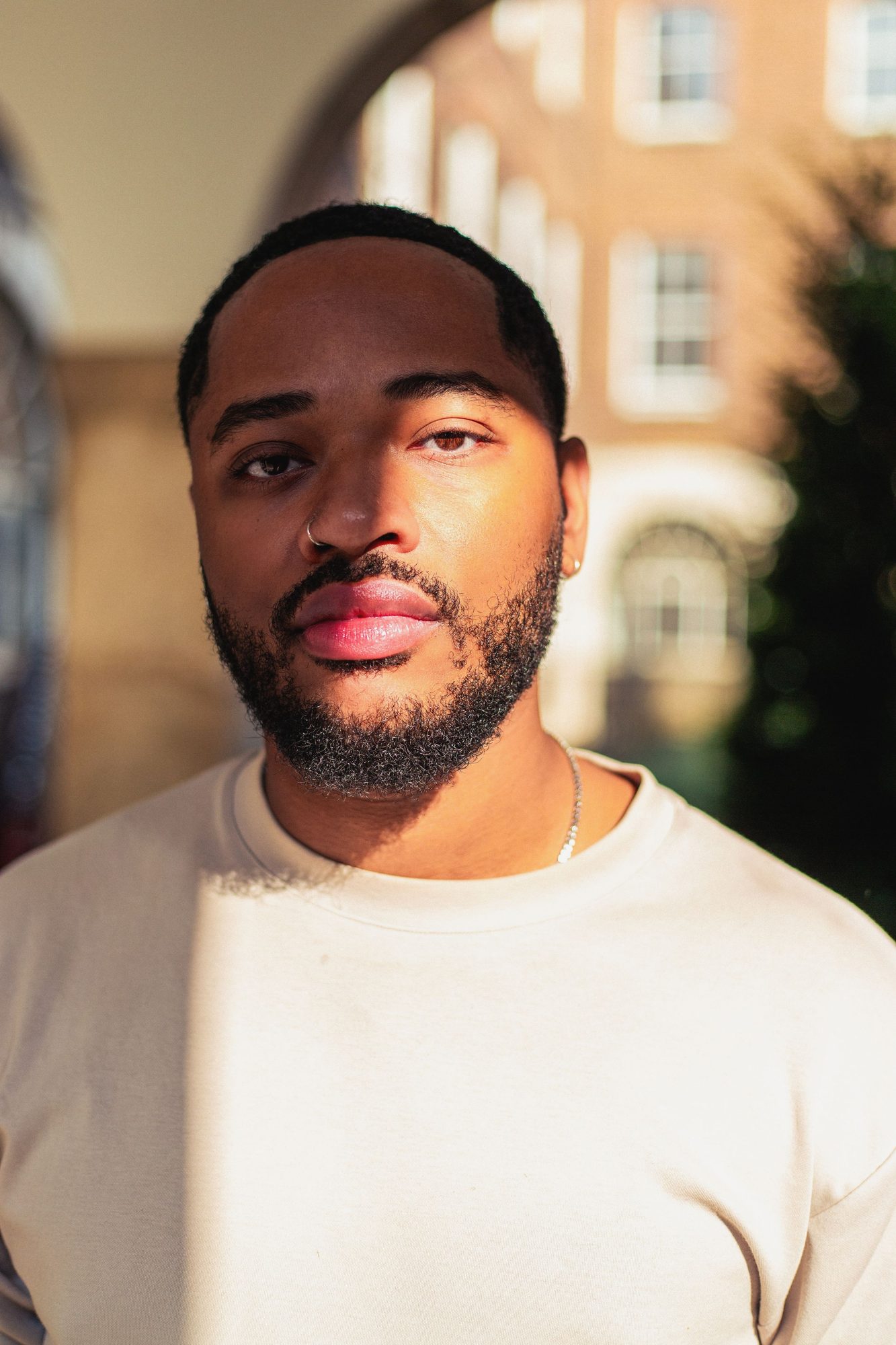 Young man in a cream t-shirt in soft afternoon light
