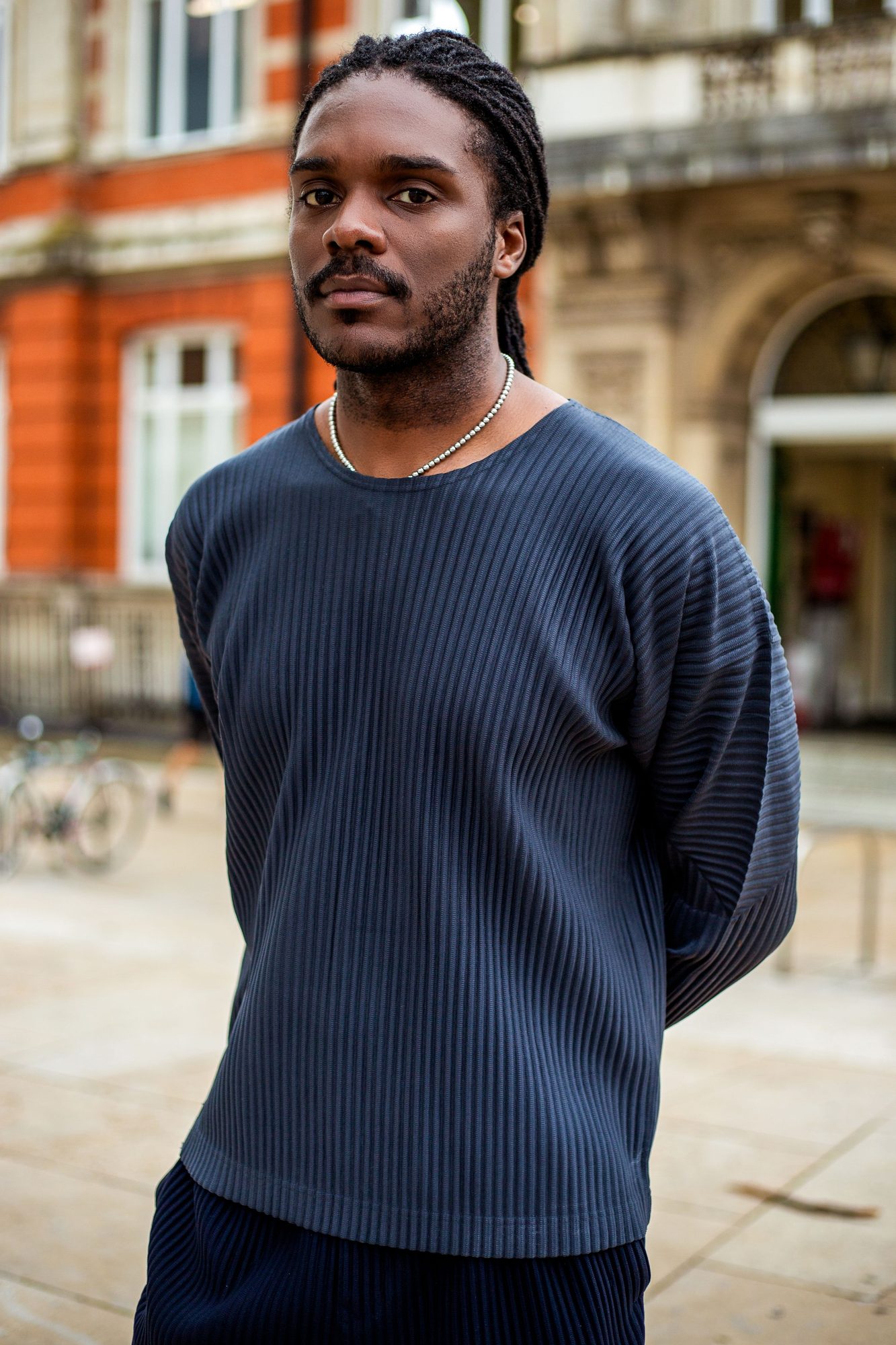 Young man in a navy knit on a red brick street