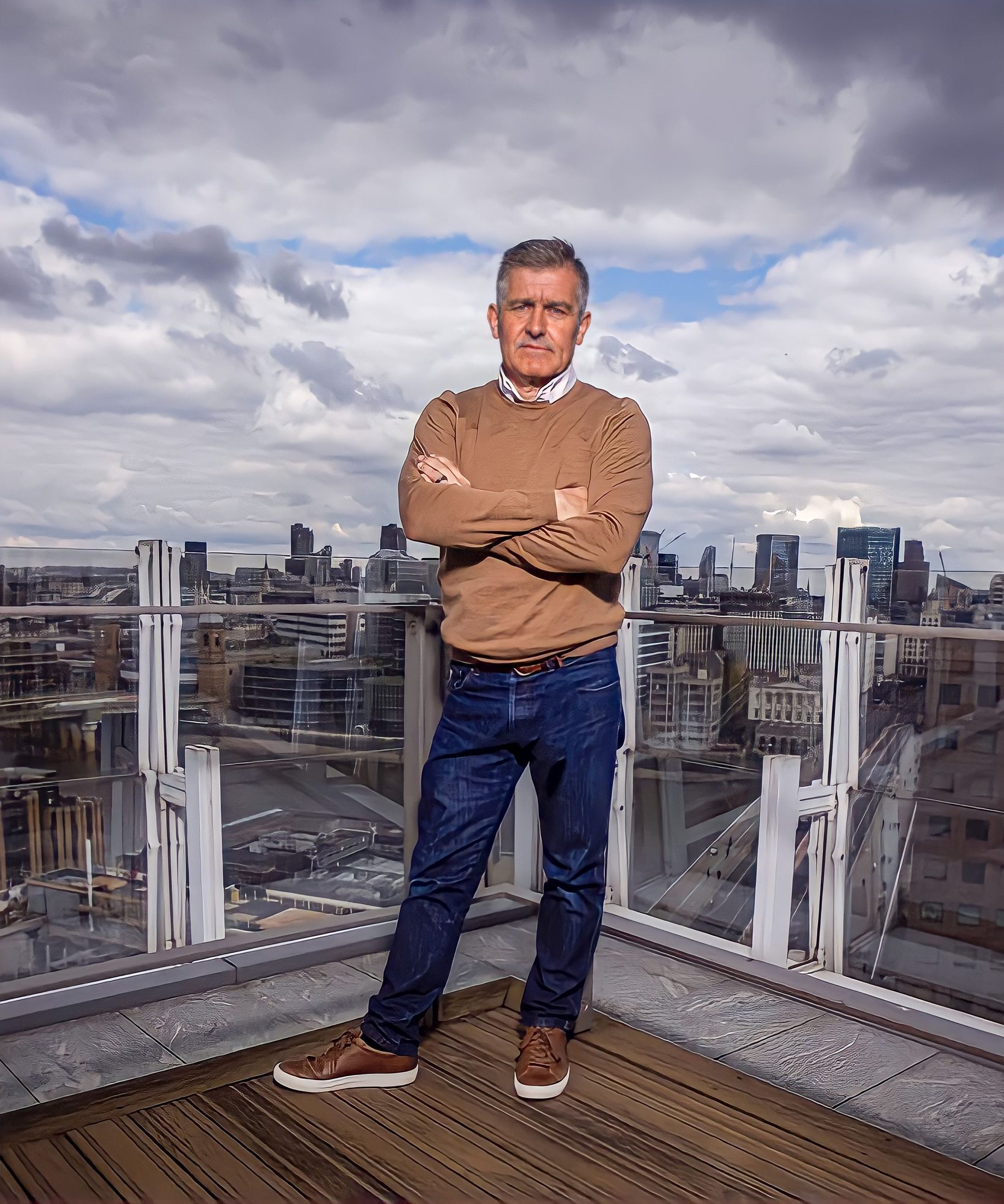 Man standing on a rooftop terrace with the city skyline behind