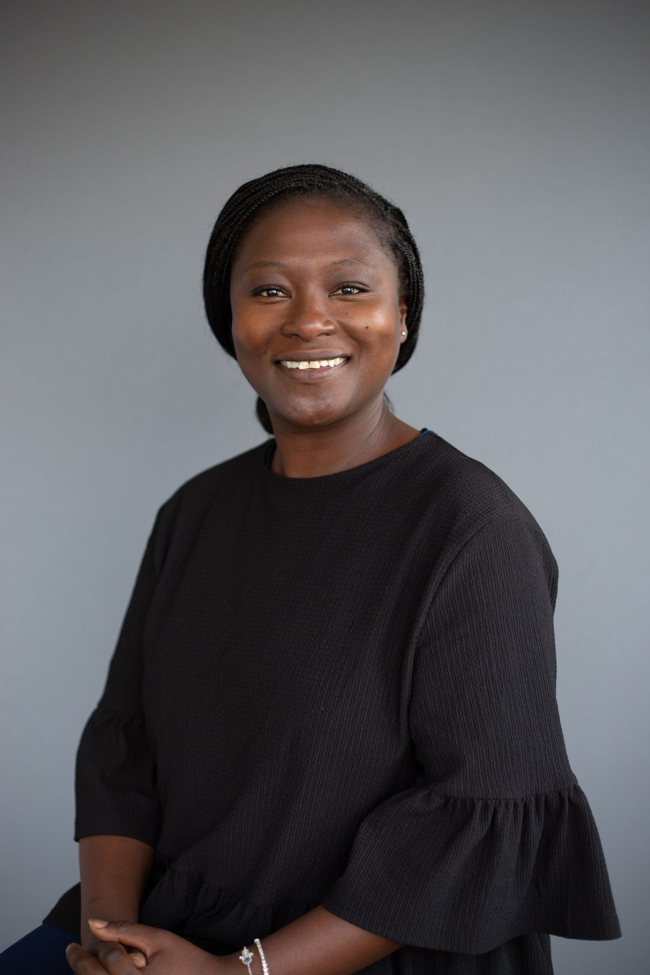Woman in a black blouse against a grey backdrop