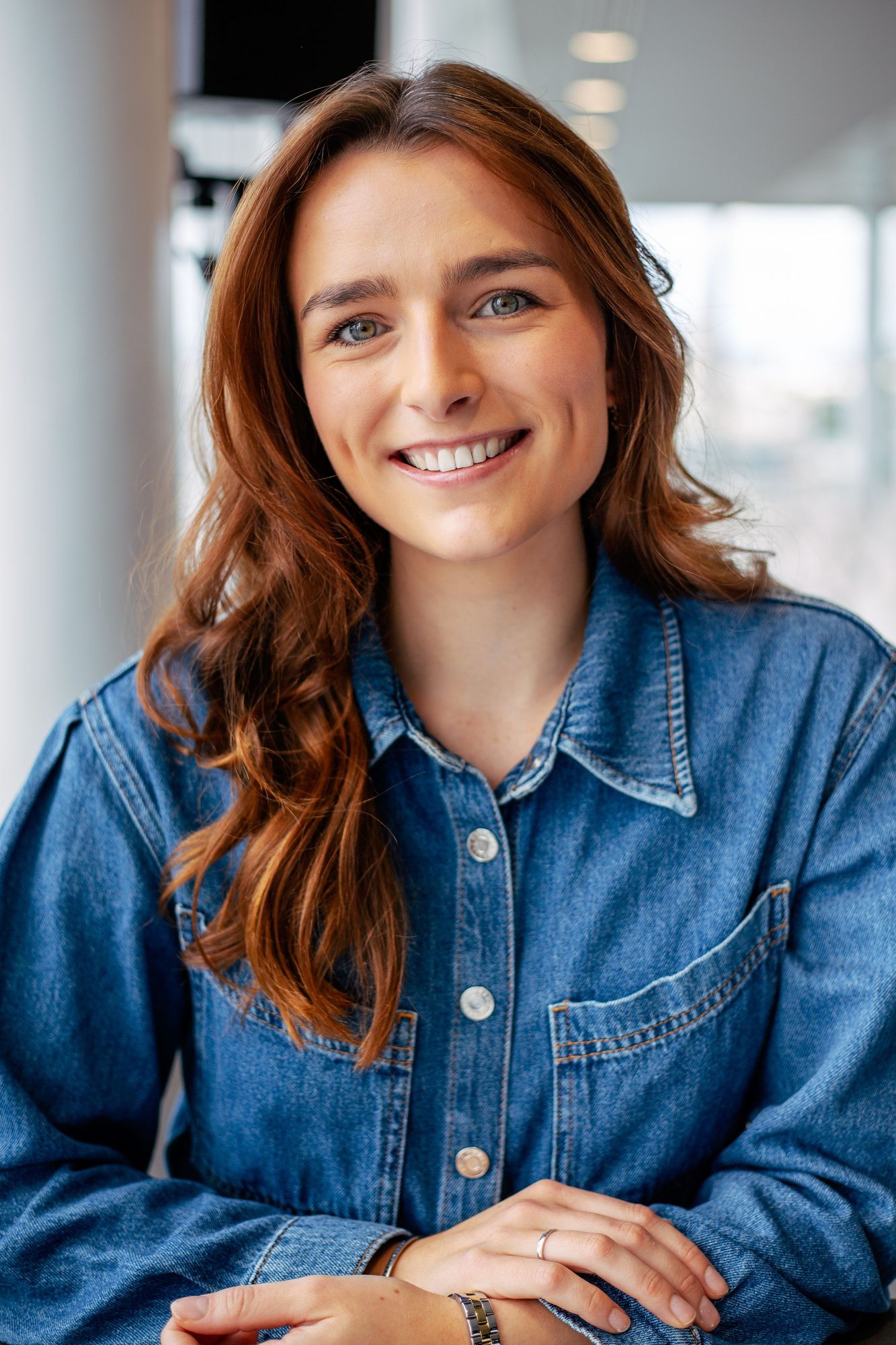 Smiling woman with red hair in a denim jacket