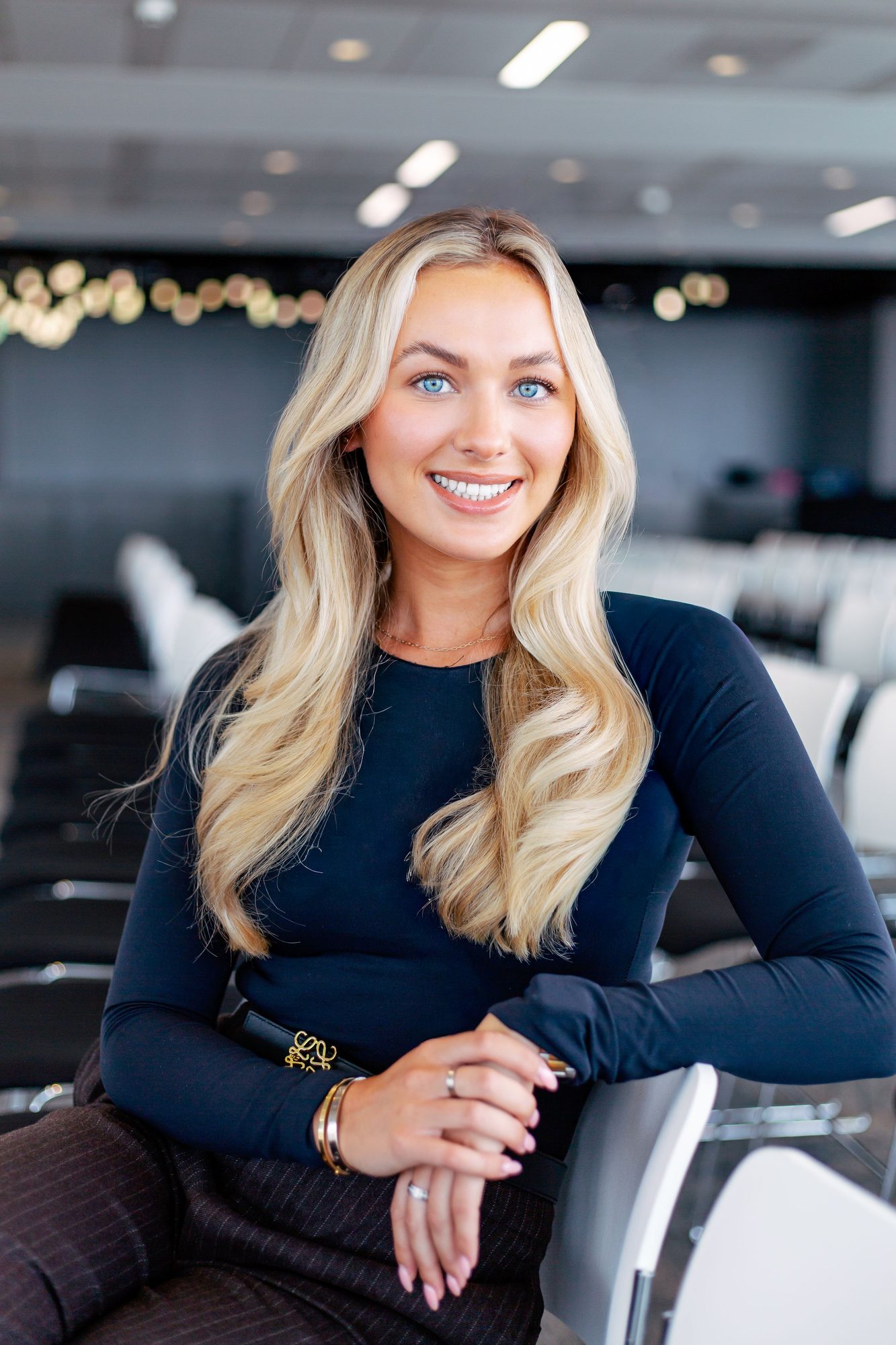 Blonde woman in a navy top seated in an office