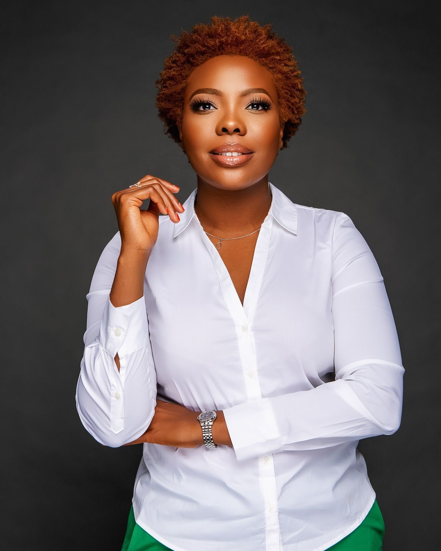 Woman with red hair in a white shirt against a black backdrop